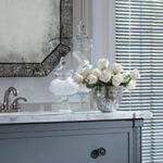 A beautiful mirror, antique vanity and marble countertop add pizzazz.