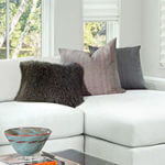 Pillows in different shades of gray add interest to a white sofa.