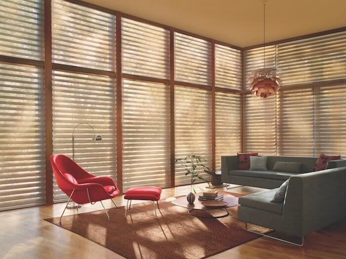 A red accent chair creates a focal point. Shown with Silhouette® window shadings.